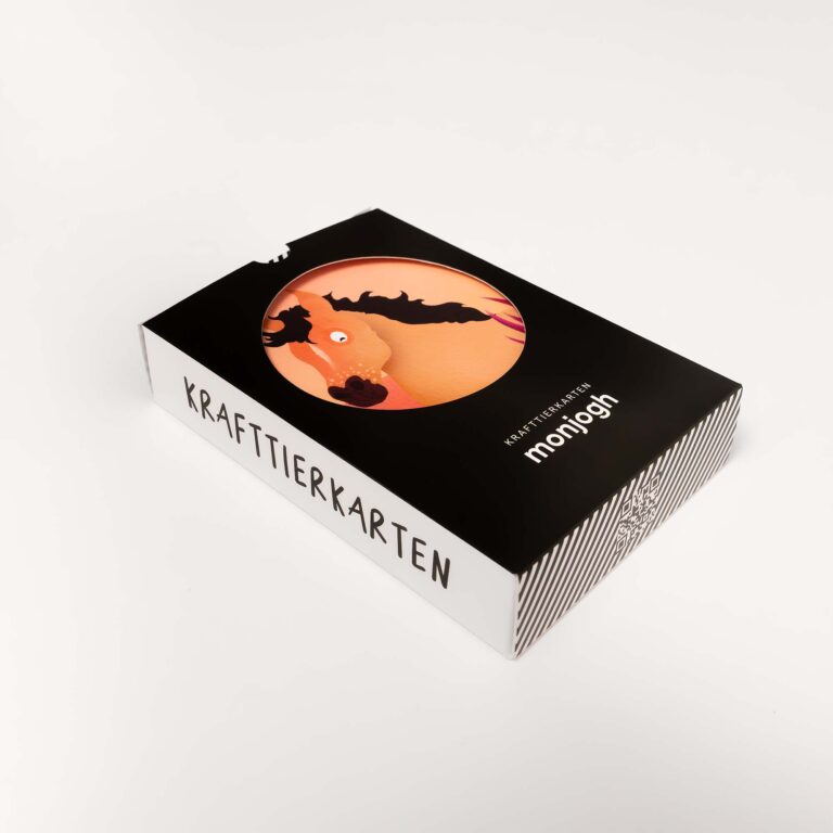 Verpackung der monjogh Krafttierkarten: schwarze Schachtel mit Fledermaus-Illustration vor orangem Kreis